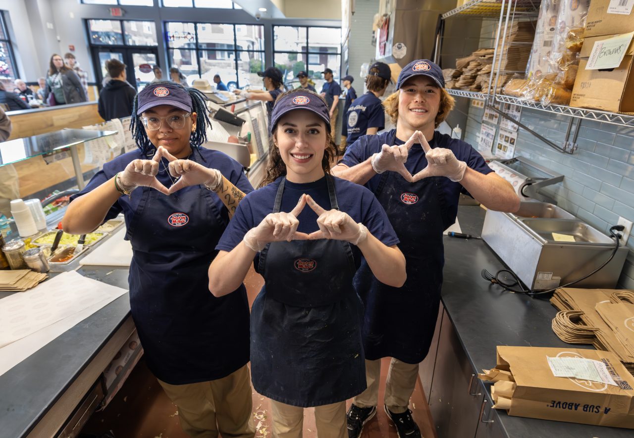 Jersey Mike's staff members at the Hershey store make diamonds with their fingers on the Jersey Mike's Day of Giving.