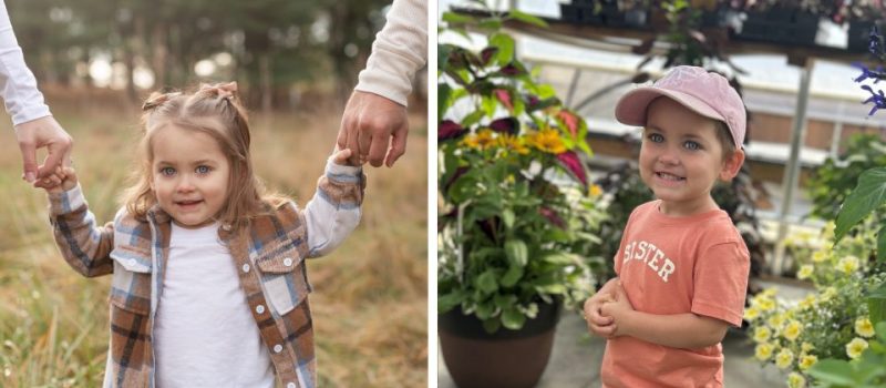 Blakely enjoying time outdoors—holding hands with two adults in a grassy field while wearing a plaid shirt, and standing among flowers in an orange 'SISTER' shirt and pink cap.