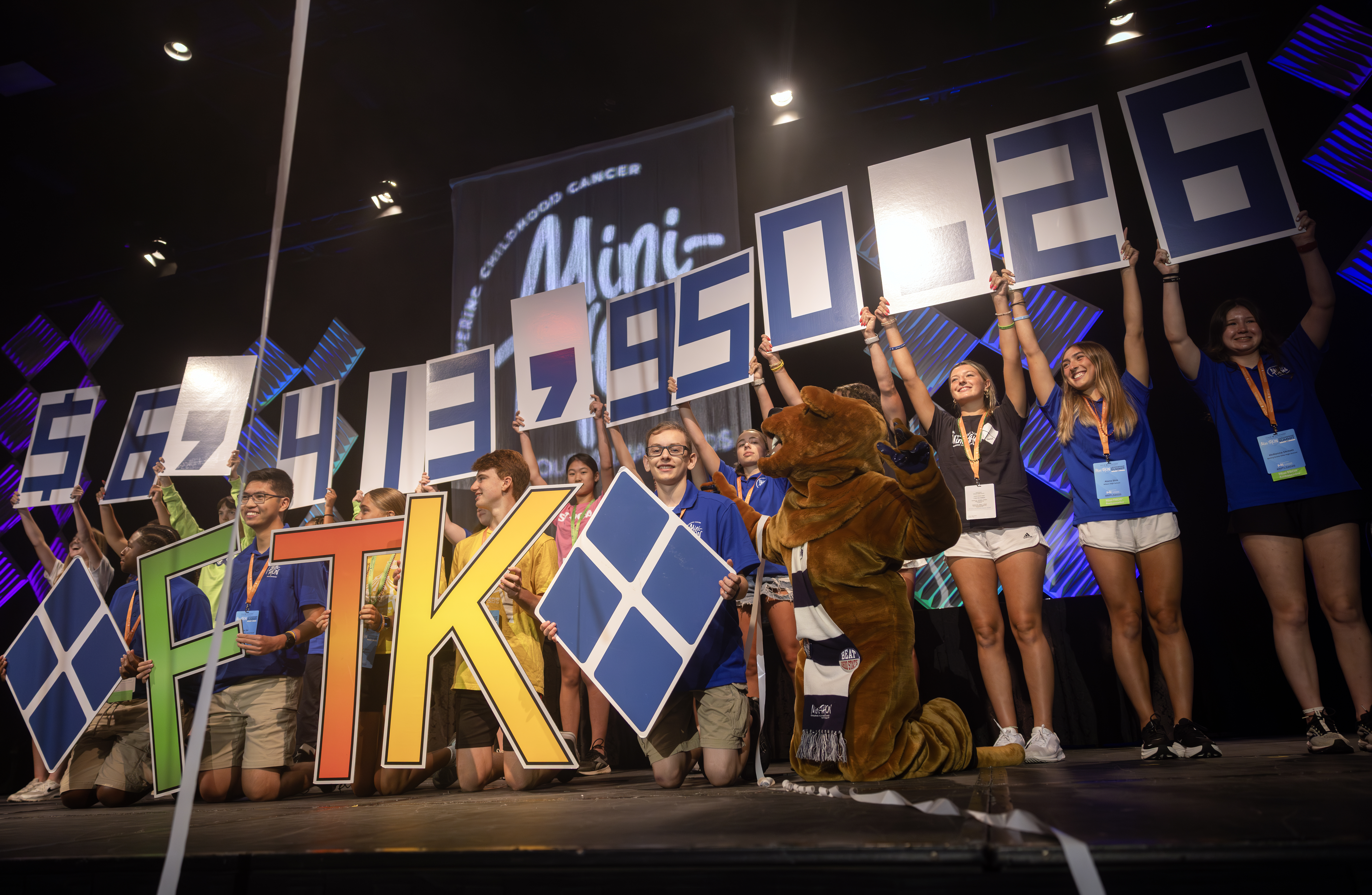 Students take to the stage at the 2025 Mini-THON Leadership Summit to unveil the total amount raised by Mini-THON events during the 2024-2025 school year.
