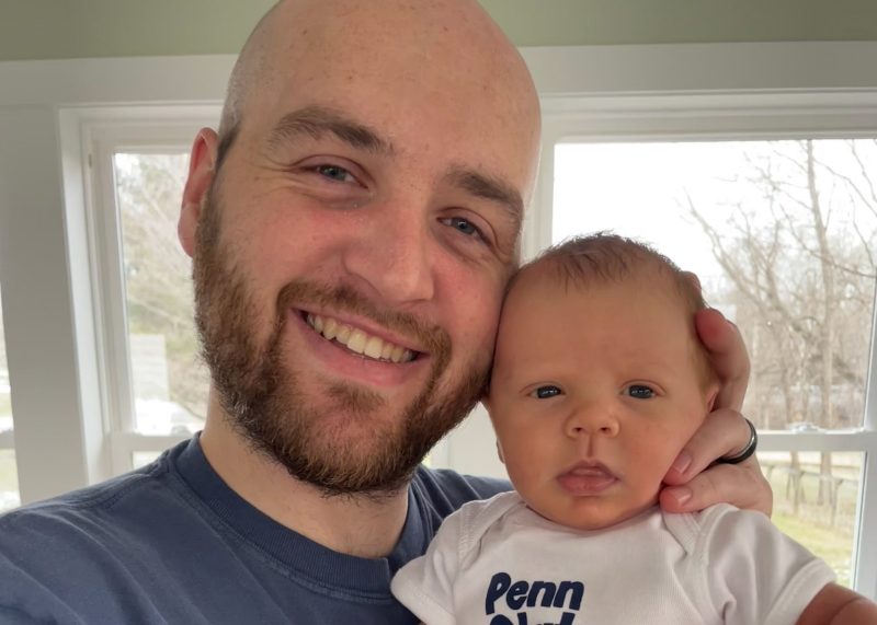 Tyler smiles while holding his son, Bennett, close during a quiet moment at home.