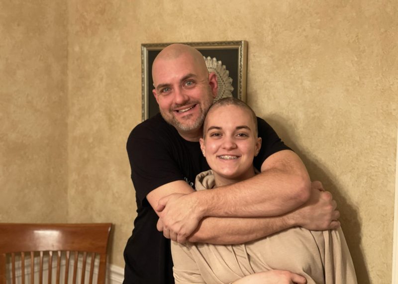 Viv hugs her father after losing her hair during treatment for Hodgkin's lymphoma.