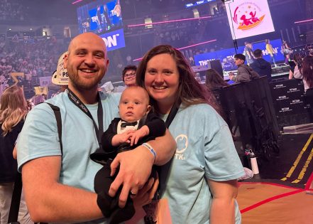 Tyler, Bennett and a family member pose together on the floor of the Bryce Jordan Center during THON 2026.