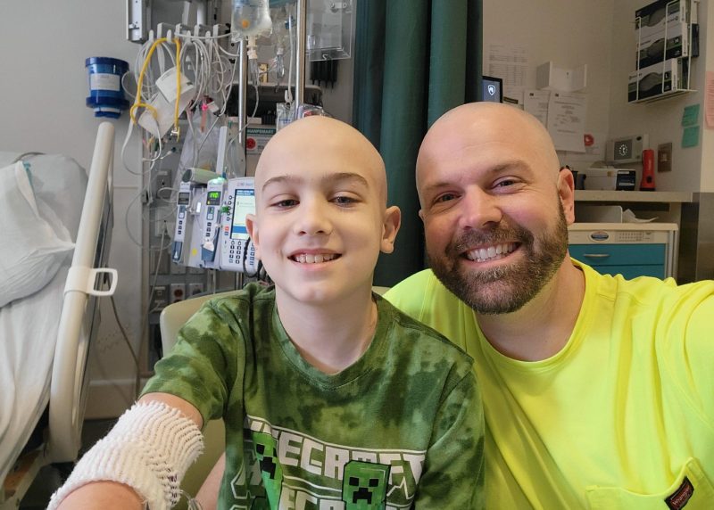 Asher smiles with his dad during his childhood neuroblastoma treatment at the hospital.