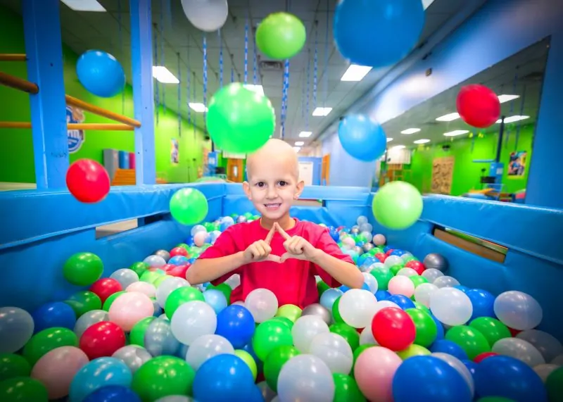 Four Diamonds child Presley, who is undergoing treatment for a Wilms tumor, plays in a colorful ball pit.