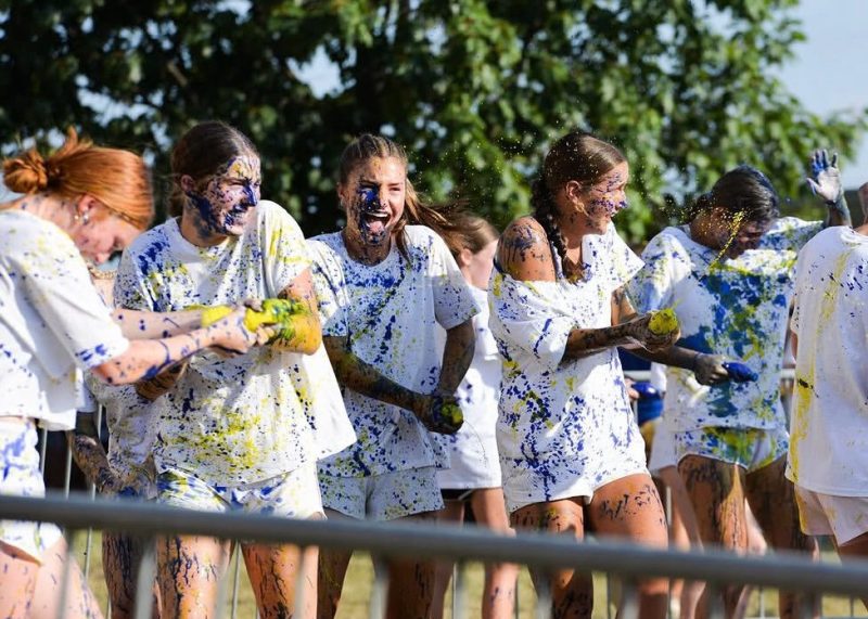 Cumberland Valley Mini-THON students celebrate while covered in blue and gold paint.