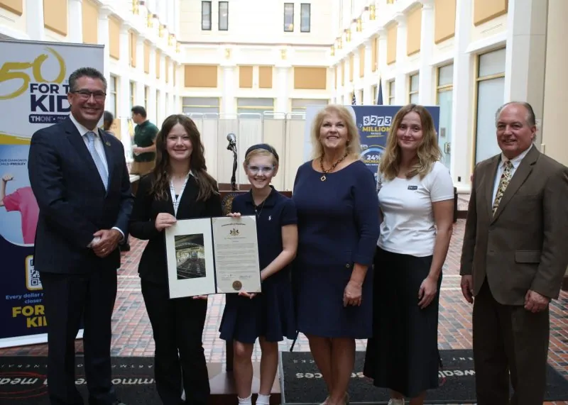 THON and Four Diamonds leaders Lauren Mellas and Suzanne Graney join Pennsylvania Reps. Tom Mehaffie and Kerry Benninghoff, alongside Four Diamonds children, to celebrate 50 years of partnership at the Pennsylvania Capitol.
