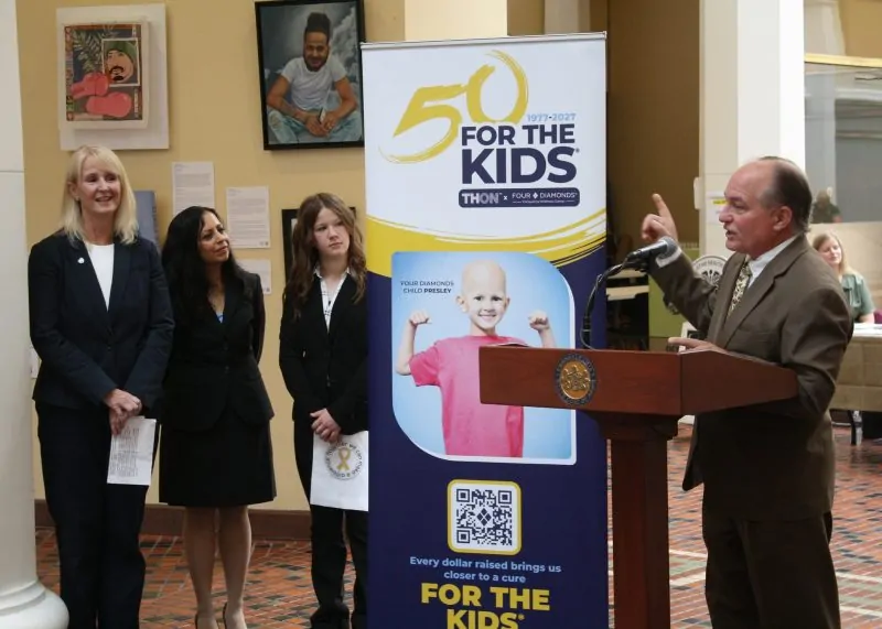 A speaker addresses attendees at a Pennsylvania State Capitol event celebrating Four Diamonds and THON's 50 years of partnership in the fight against childhood cancer.